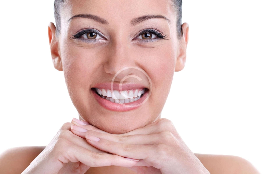 Woman smiling and showing bright white teeth after cosmetic dental treatment.